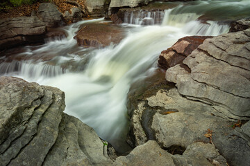 Fast-Flowing Cascade Surrounded by Layered Rock Formations