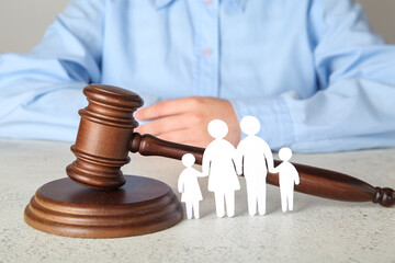 Woman with figures of family and judge's gavel on light table