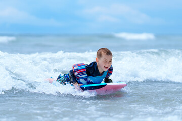 Obraz premium Beach body boogie boarding wave summer fun, boy child smiling happy