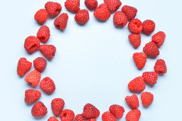Frame made of fresh raspberries on blue background