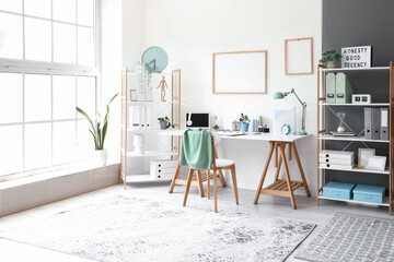 Interior of light office with workplace and shelving units