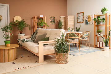 Interior of cozy room with plants, sofa and dining table