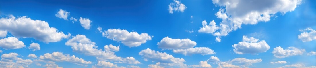 Fototapeta premium Fluffy white clouds scattered across a vast expanse of vibrant blue sky