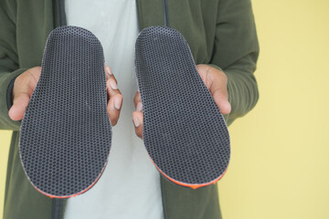 New shoe insoles being held against a bright backdrop