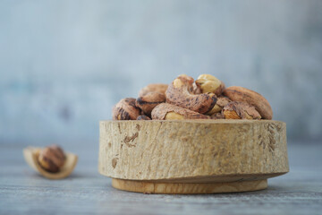  cashew nuts arranged in a wooden bowl on a table