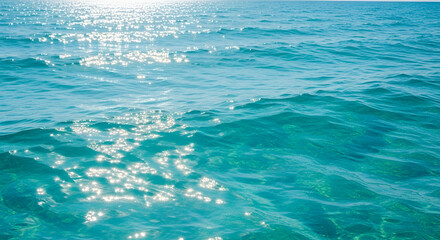 Obraz premium Sparkling turquoise water surface reflecting sunlight.