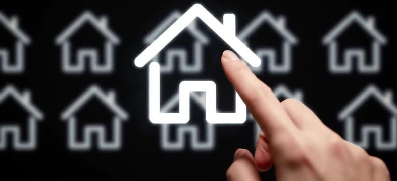 A hand selects a glowing house icon among many on a black screen, conveying choice, property or real estate