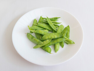 Snow pea pods, also known as Chinese pea pods, are a type of edible pea pod that is harvested while still immature and flat with small peas inside. Sugar Pea in a plate