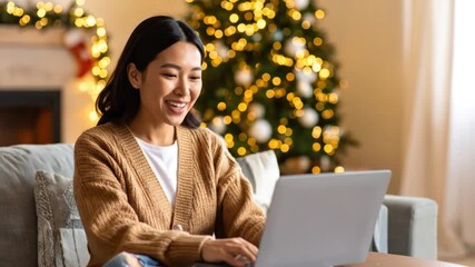 Young Asian woman celebrating Christmas online using a laptop for a video call