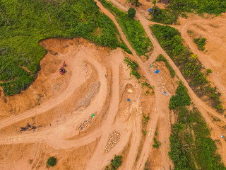 A tractor is mining rocks and sand as seen from the air, around an agricultural area, in a rural area in East Kutai Regency, East Kalimantan, Indonesia.