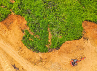 A tractor is mining rocks and sand as seen from the air, around an agricultural area, in a rural area in East Kutai Regency, East Kalimantan, Indonesia.
