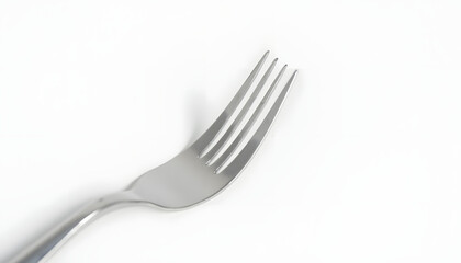 Close-up shot of a shiny, silver fork resting on a white surface, casting a shadow.