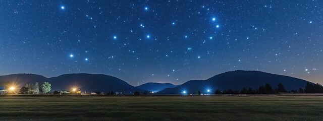 Fototapeta premium Starry night over rolling hills and distant lights.