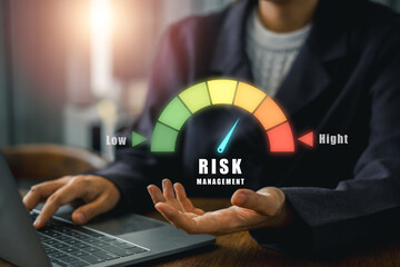 A business professional evaluates risk management using a digital gauge indicating low to high risk...