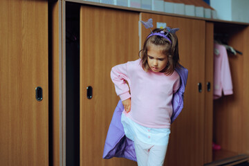 Student Removes her Jacket at School During Winter Season. Little child getting ready for a new...