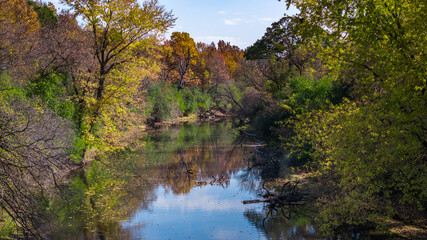 Scenic river with tree-lined shore in vibrant fall colors