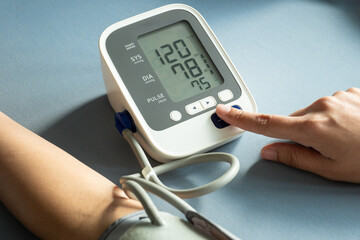 woman check blood pressure monitor and heart rate monitor with digital pressure gauge. Health care and Medical concept