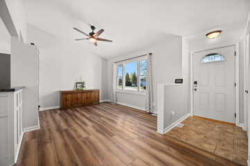 Empty Front Sitting Room with View of Front Door and Blue Skies Through Windows