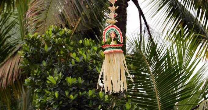 Sampian penjor ornament, symbol of Balinese cultural richness, delicately sways in breeze. Slow-motion footage captures intricate details of this hanging decoration