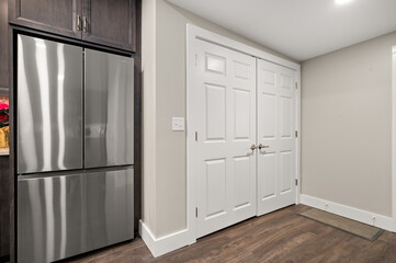 Kitchen Pantry Door Next to Stainless Steel Refrigerator