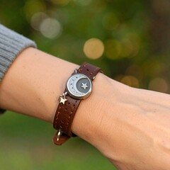 Fototapeta premium Woman's hand wearing a modern leather watch