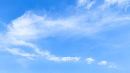 Bright blue sky with soft fluffy clouds on a summer day. Blue sky with clouds. Soft white clouds float in the clear blue sky. Clear blue sky, bright spring, wallpaper landscape.