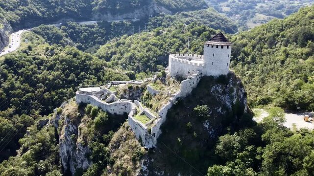 Aerial view of medieval hilltop fortress near Uzice, Serbia, surrounded by forest and mountains. C.