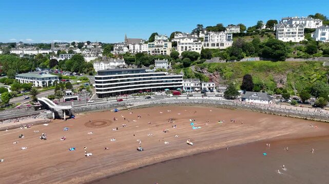 Aerial footage of Torquay Beach and Torre Abbey Sands Beach on a sunny day in Torquay, England, UK