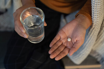 Health and Wellness. Individual preparing to take medication with water.