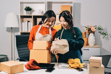 Portrait of Starting small businesses SME owners, two Asian woman check online orders Selling...