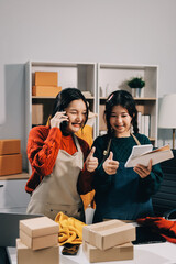 Portrait of Starting small businesses SME owners, two Asian woman check online orders Selling...