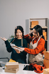 Portrait of Starting small businesses SME owners, two Asian woman check online orders Selling...