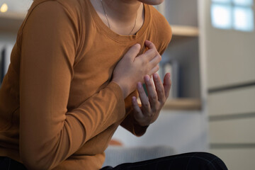 Health Awareness: Young woman feeling chest discomfort at home