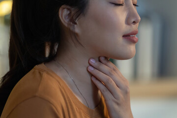 Health Awareness. Young woman showing signs of discomfort while touching her throat.