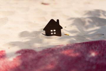 Wooden house on shifting sand symbolizes a declining real estate market. It captures a market...