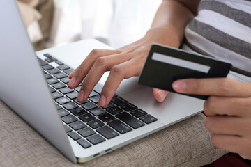 Female Hands Holding Credit Card and Using Laptop.