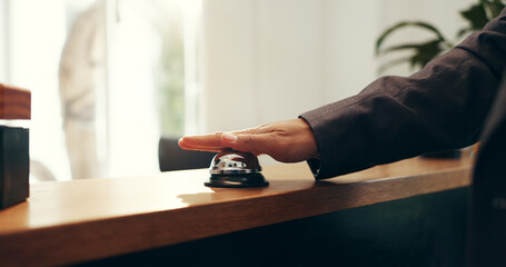 Person, hands and ringing with service bell for reception or request assistance in hotel. Closeup,...
