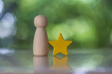Wooden peg doll standing together with yellow star. The concept of a candidate. Choosing the best...