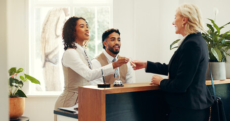 Concierge, keys and help desk with people in hotel for check in assistance, reservation and...