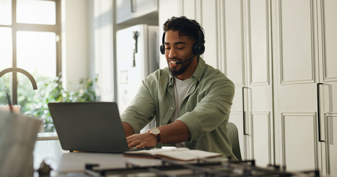 Man, headset and laptop in kitchen for remote work, typing and advice for customer care call center. Technology, freelance help desk and consultant or virtual assistant for telecom support in home