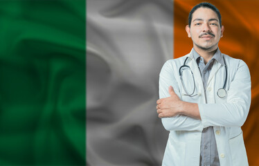 Male doctor on Ireland flag. Doctor with crossed arms on Ireland flag. Ireland Health and Care...