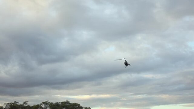 Camera tracks helicopter flying low over South African landscape