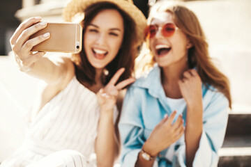 Two young female stylish hippie brunette and blond women models in summer sunny day in hipster...