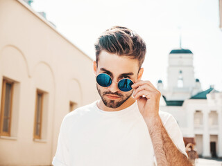 Portrait of handsome confident stylish hipster lambersexual model.Man dressed in white T-shirt....