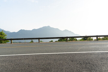 Fototapeta premium empty asphalt through mountain as background