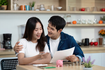 Financial Planning and Savings. Couple reviewing financial documents with piggy bank.