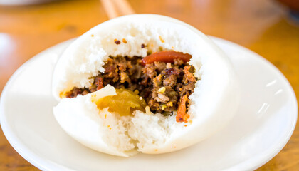 Delicious Steamed Bun: A close-up shot showcases a delicious steamed bun, its fluffy exterior gently revealing a savory filling. This tempting food photography.