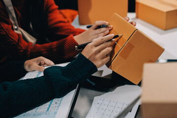 Portrait of Starting small businesses SME owners, two Asian woman check online orders Selling...