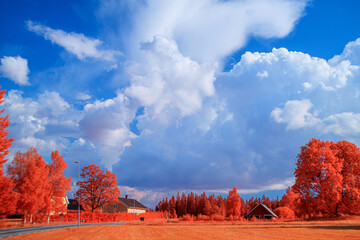 Infrared landscape with white clouds and blue sky
