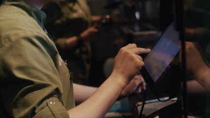 Barista using a touch screen to manage orders in a busy coffee shop - Powered by Adobe